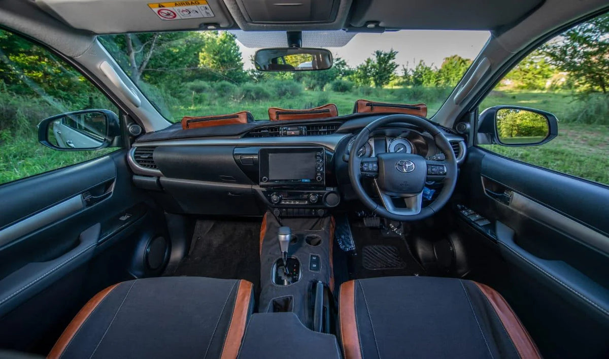 Beesdam African custom-fit dash cover with tan leather pockets fitted in a Toyota Hilux interior