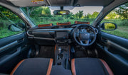 Beesdam African range dash cover with tan leather storage pockets fitted across a Toyota Hilux dashboard