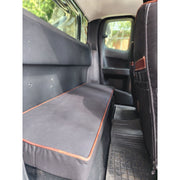 Beesdam rear bench cover fitted in an extended-cab bakkie, Charcoal polycotton with leather piping in Red Brown